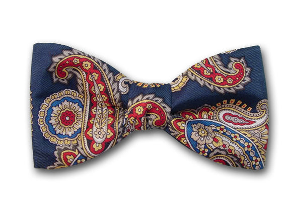 Red, yellow, white, beige and black paisley on blue. Pure silk twill bow tie.