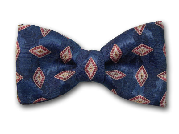 Small red and beige patterns on navy. Silk bow tie for men.