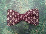 Christmas bow tie on the tree. Brown on green beckgrownd.