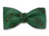 Christmas bow tie with starry tree on green.