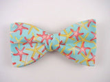 Pink and yellow starfish on  blue bow tie.